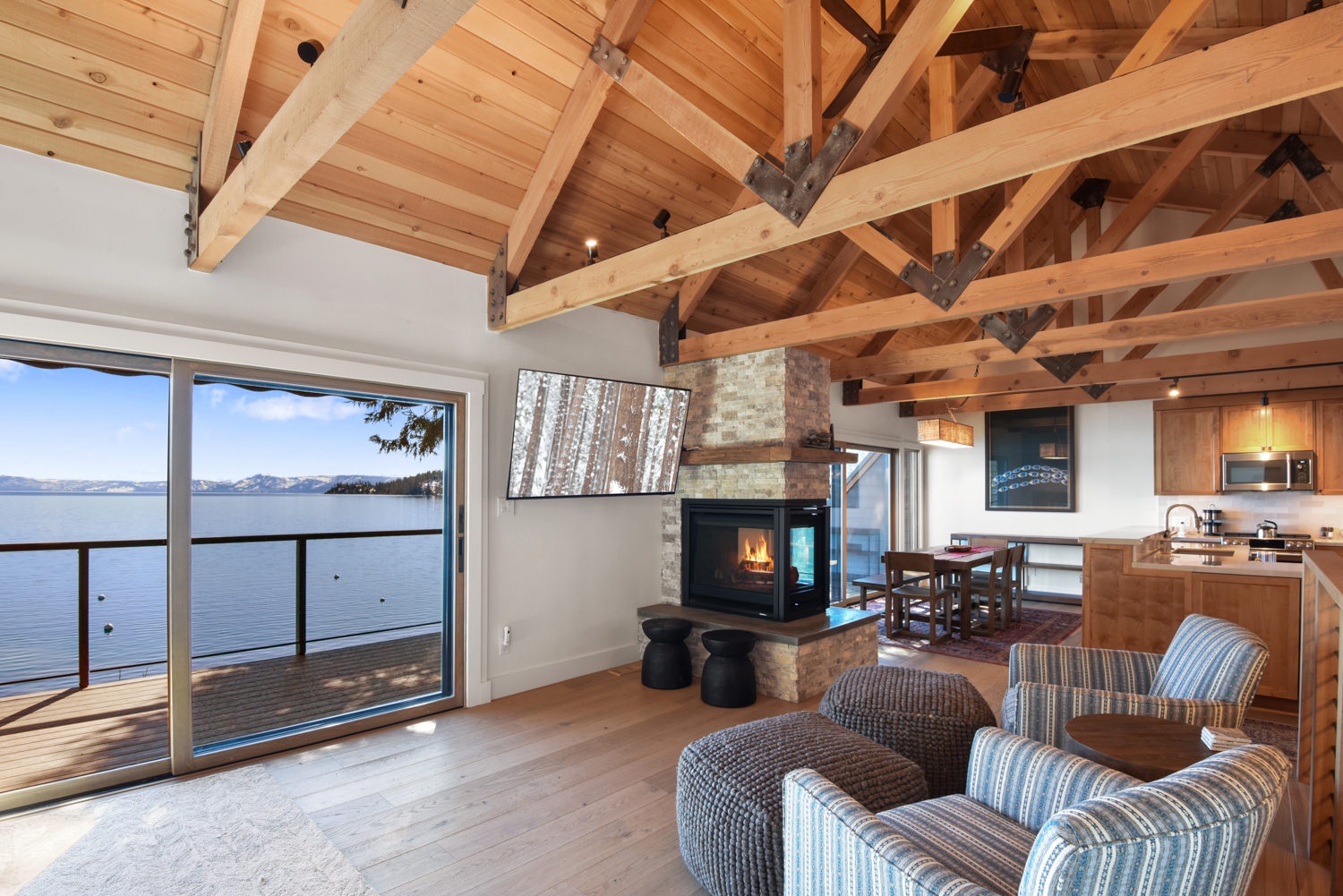 Open living space with lake view, TV, and fireplace