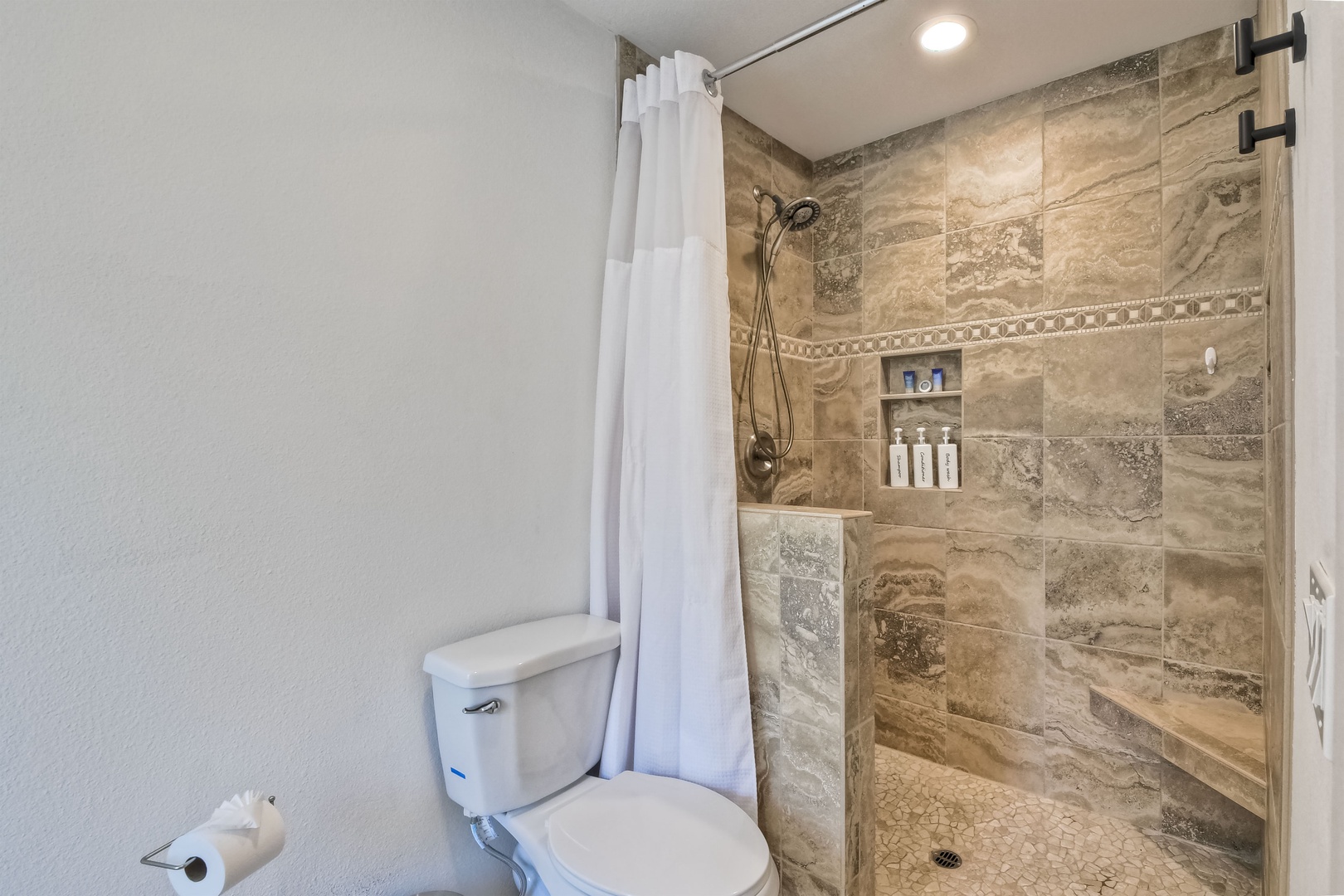 Ensuite bathroom with dual sinks, soaking tub, and stand-up shower