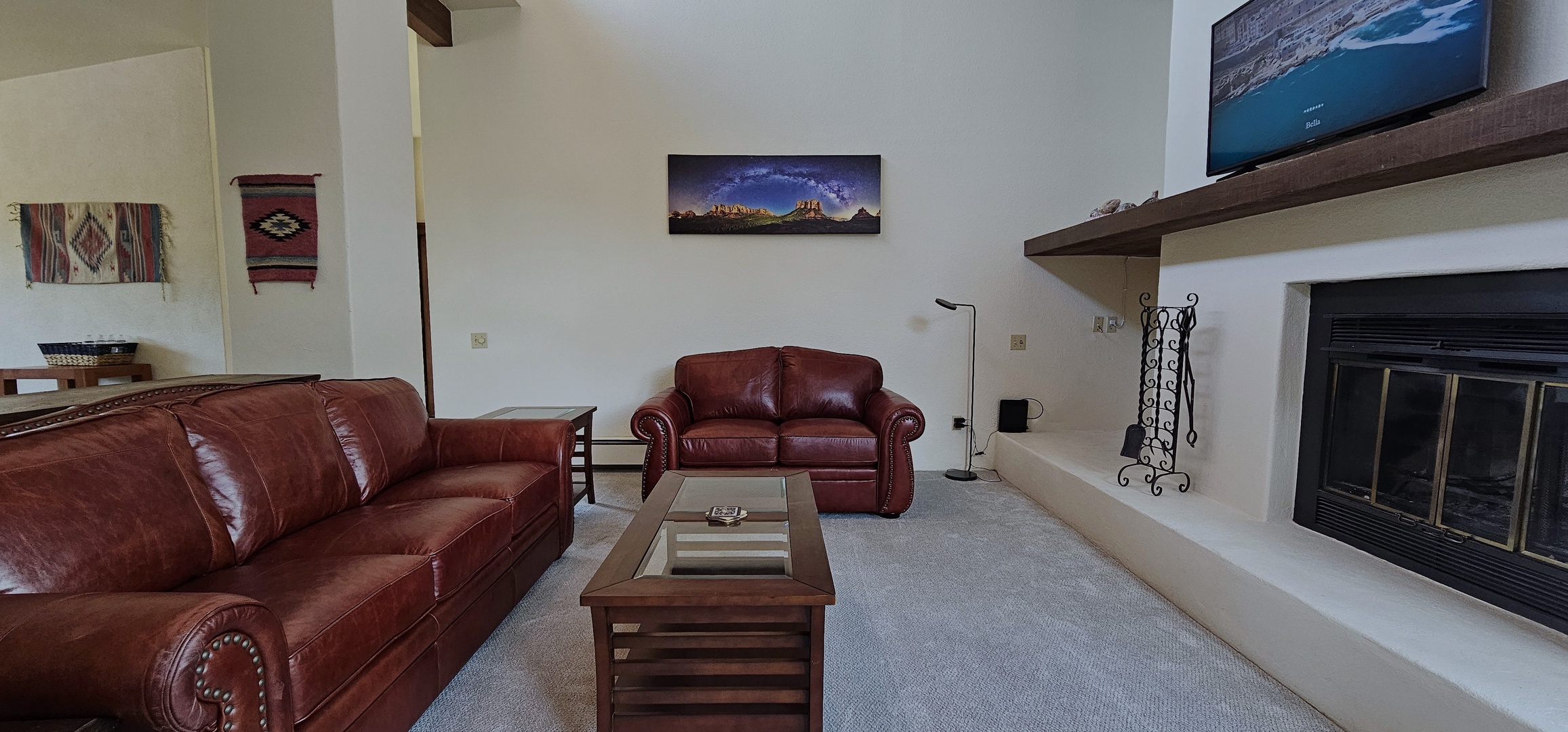 Living room with fireplace, leather seating, and Smart TV