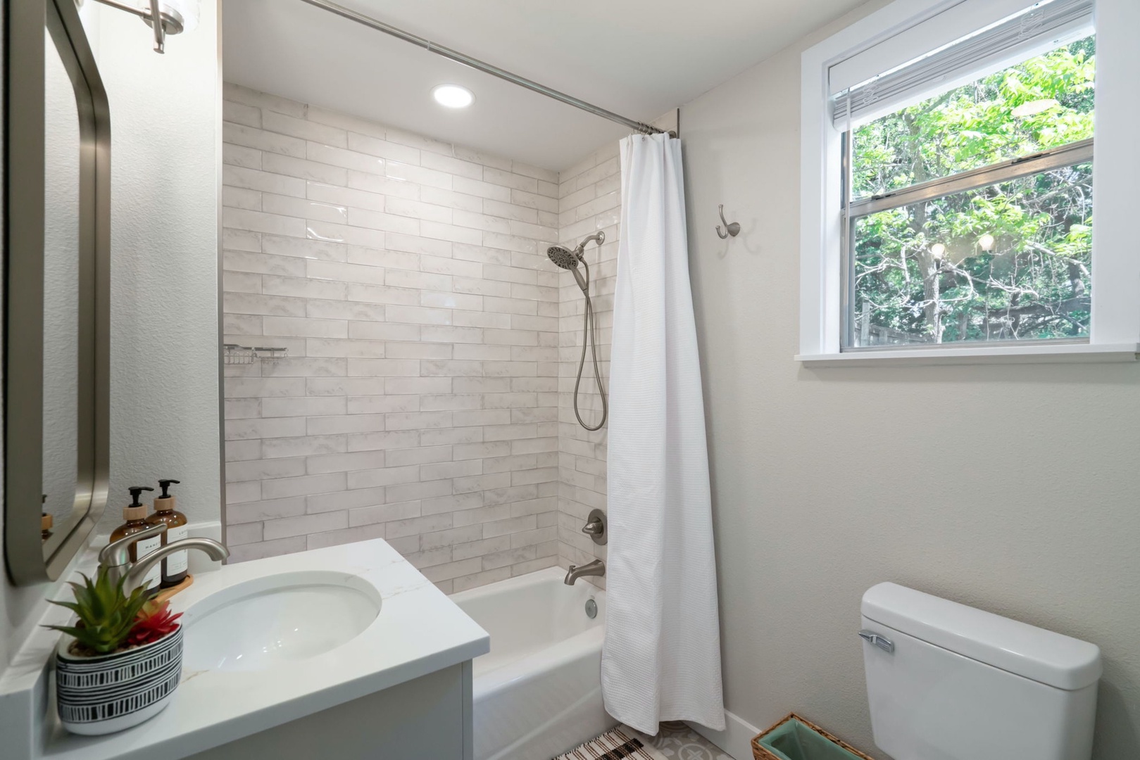 The Studio’s chic full bathroom features a single vanity & shower/tub combo