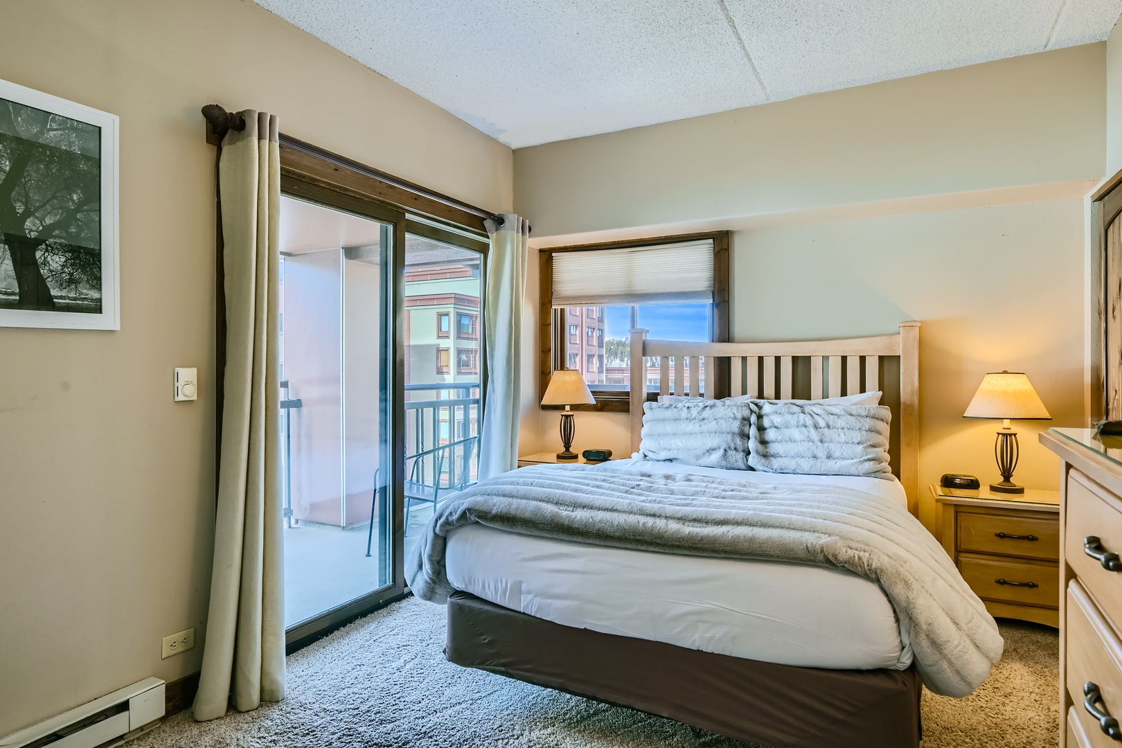 The private bedroom features a plush queen bed & stunning balcony views