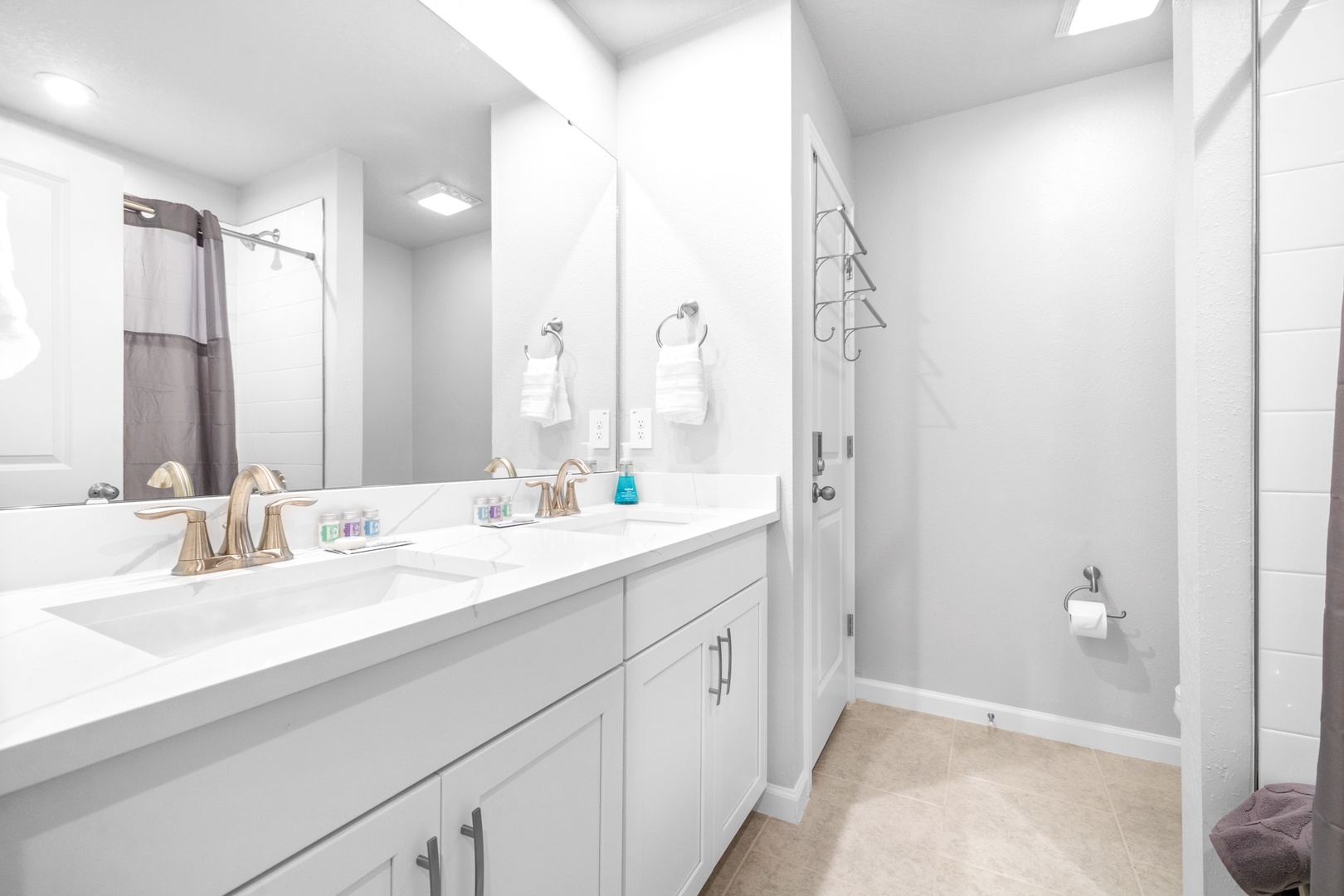 The tranquil shared bathroom includes a large double vanity & shower/tub combo