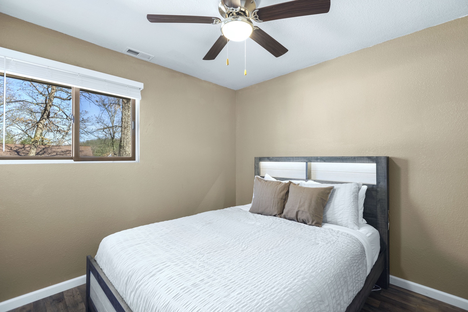 This bedroom retreat offers a queen-sized bed & ceiling fan