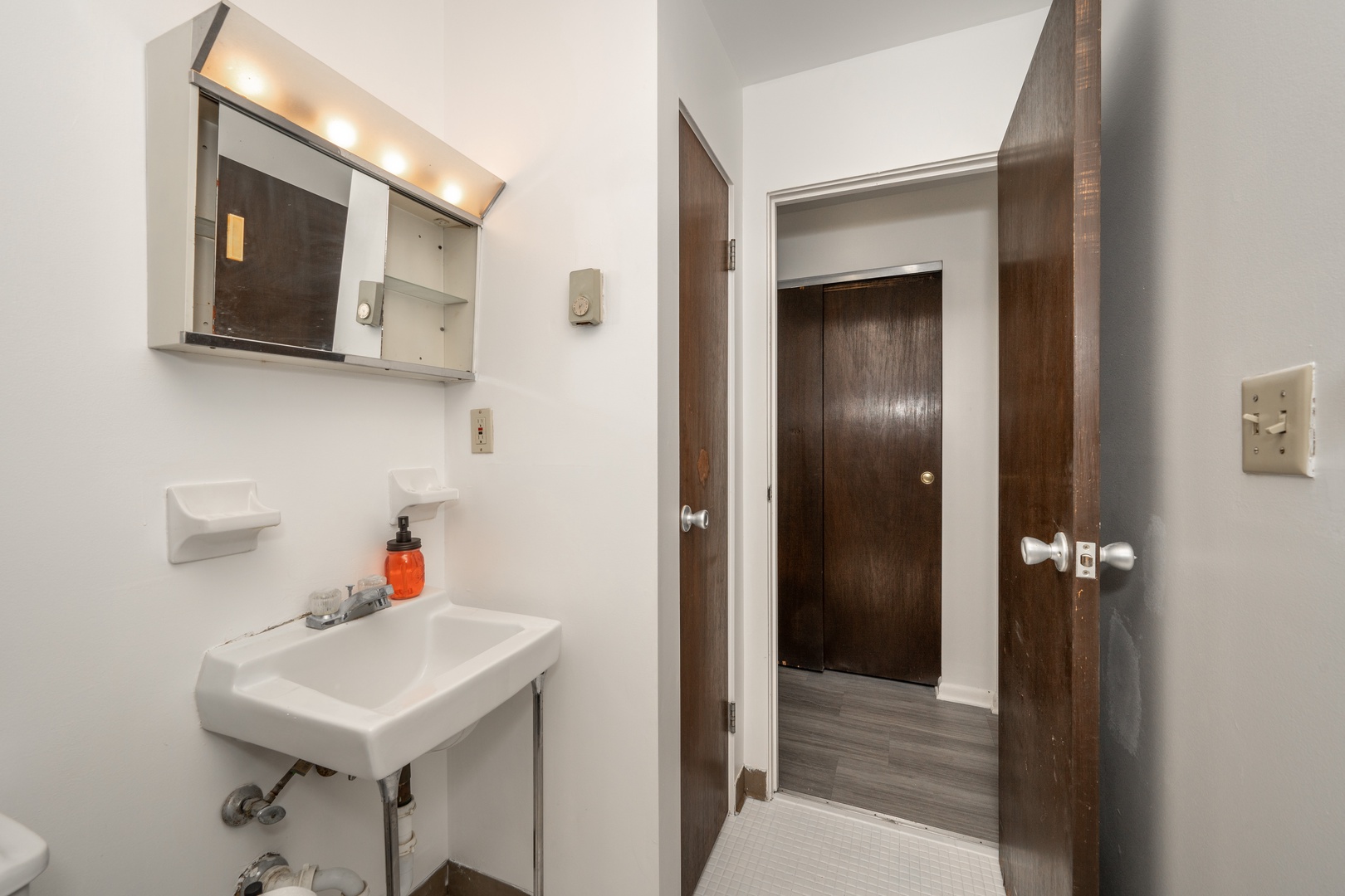A shower/tub combo & single vanity awaits in the full bathroom