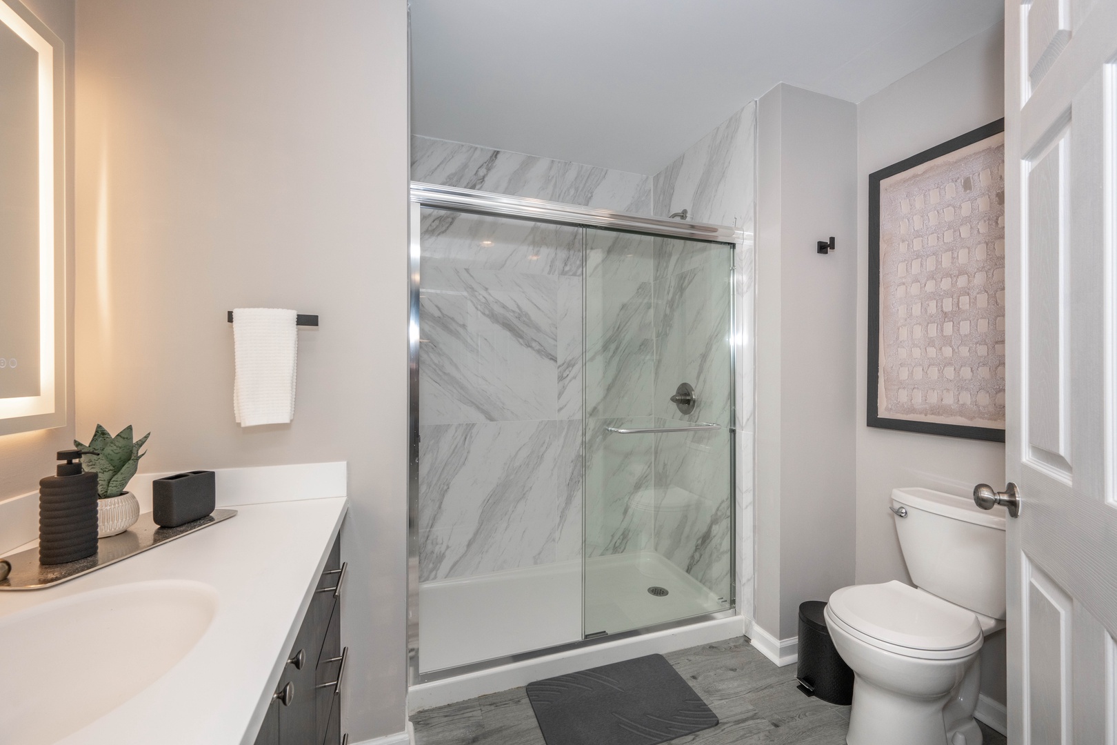 Rejuvenate in the full bath, featuring a large single vanity & glass shower