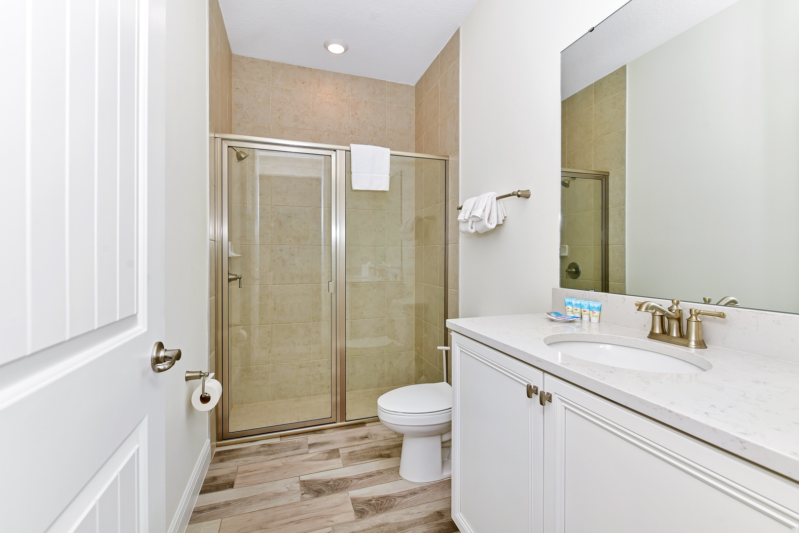 This charming bath features a single vanity & glass shower