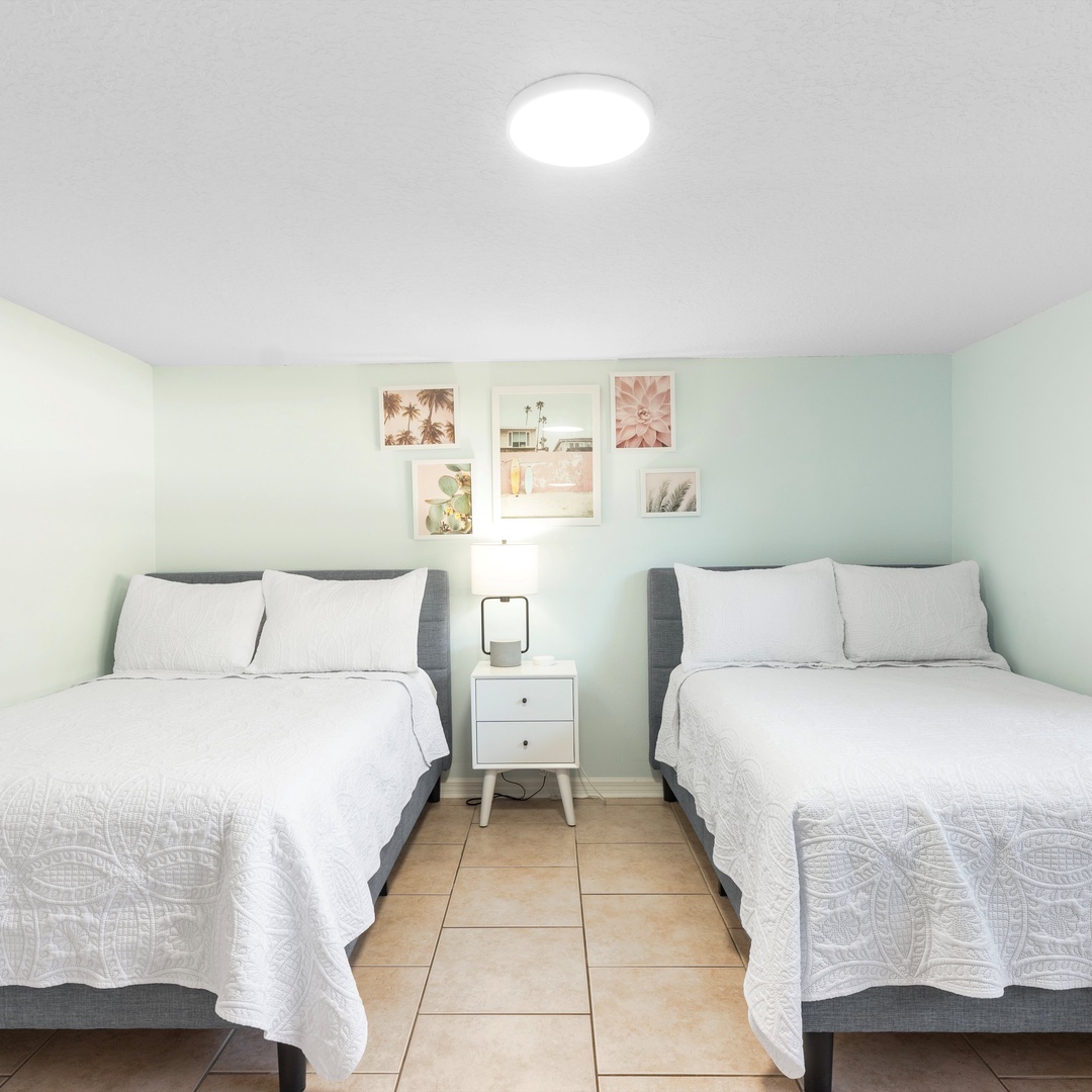 The second bedroom offers a pair of full-sized beds & Smart TV