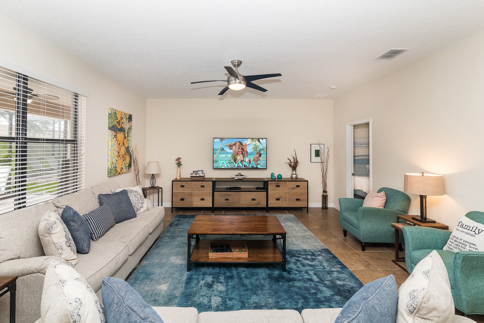 Open living space with with ample seating, Smart TV, and pool patio access