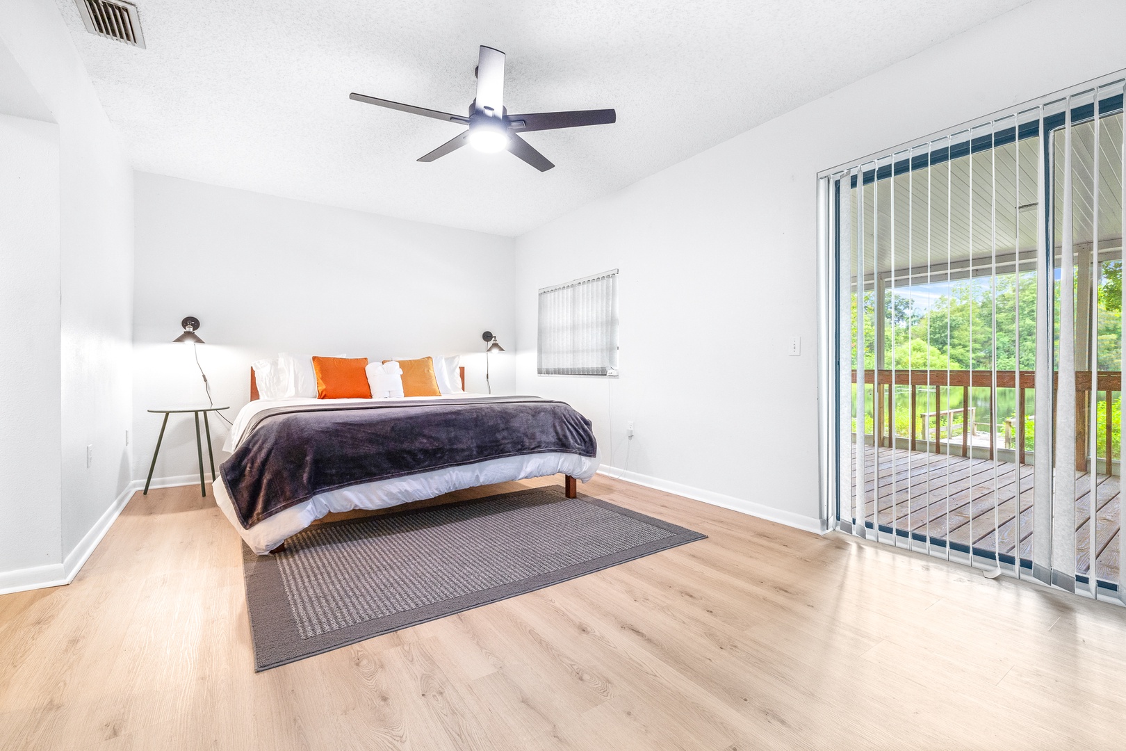 The spacious master bedroom boasts a king bed, smart TV, & patio access