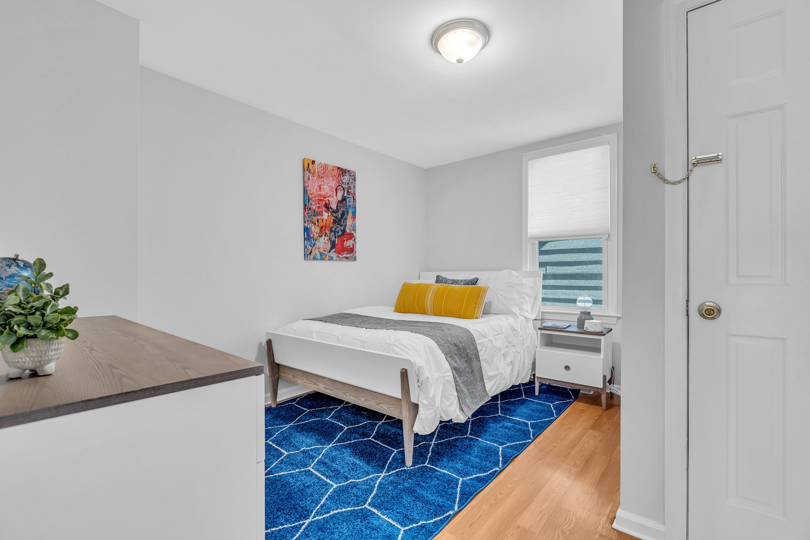 The second bedroom in Unit 1 features a stylish full-sized bed