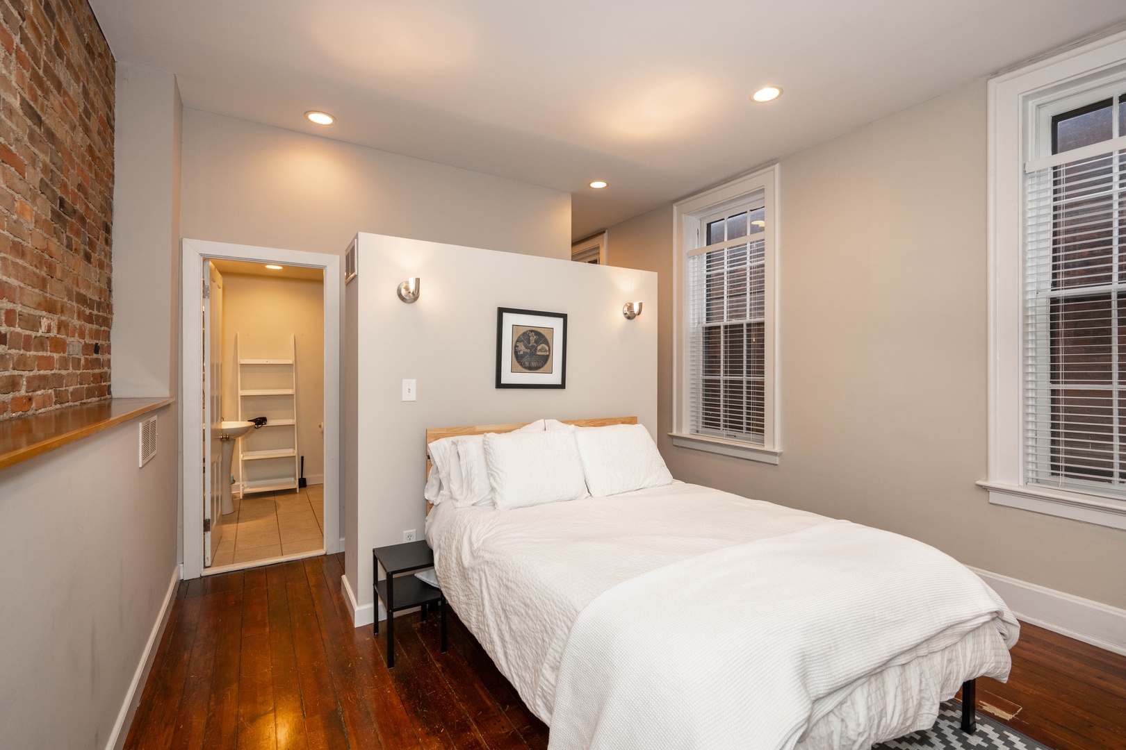 The loft sleeping area boasts a plush queen bed, ensuite, & laundry access