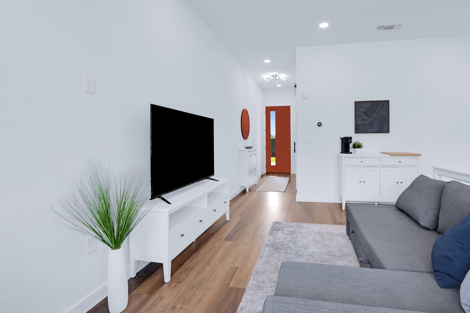 Bright living space with queen sofa sleeper, Smart TV, and workspace