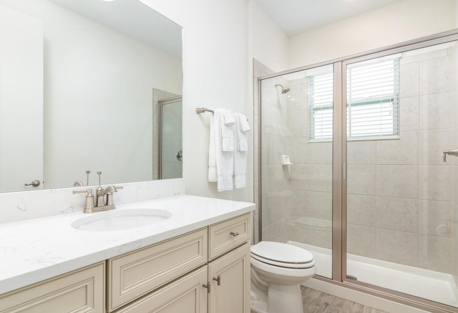 A single vanity & shower await in this large ensuite bath to double twin bedroom