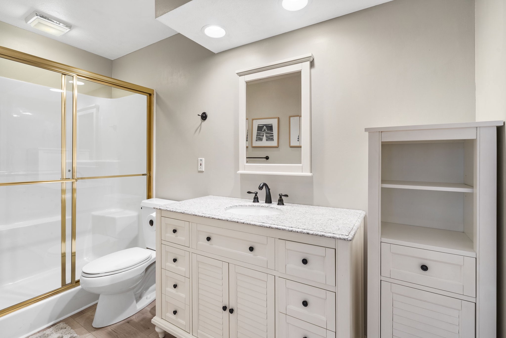 The second of two full bathrooms includes a single vanity & glass shower