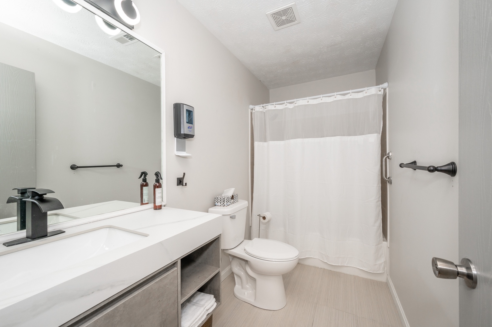 The full bathroom features a single vanity & shower/tub combo