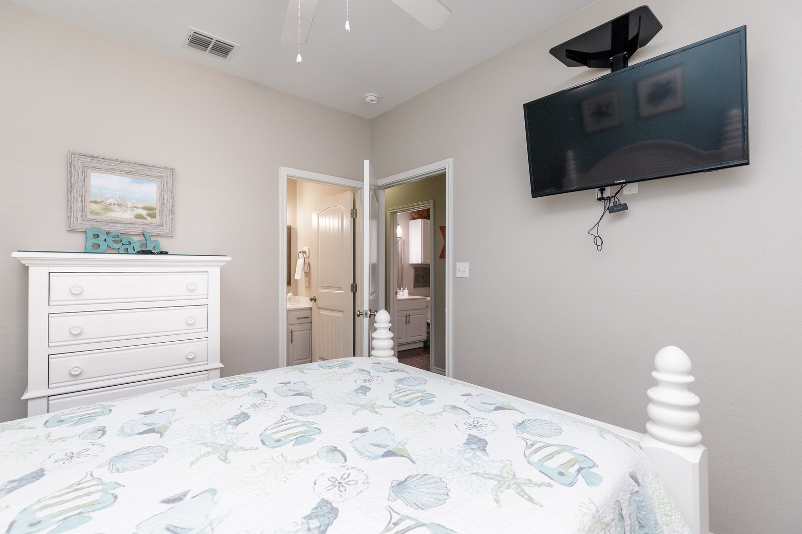 The 1st of 3 first-floor bedrooms offers a full bed, en suite bath, & Smart TV