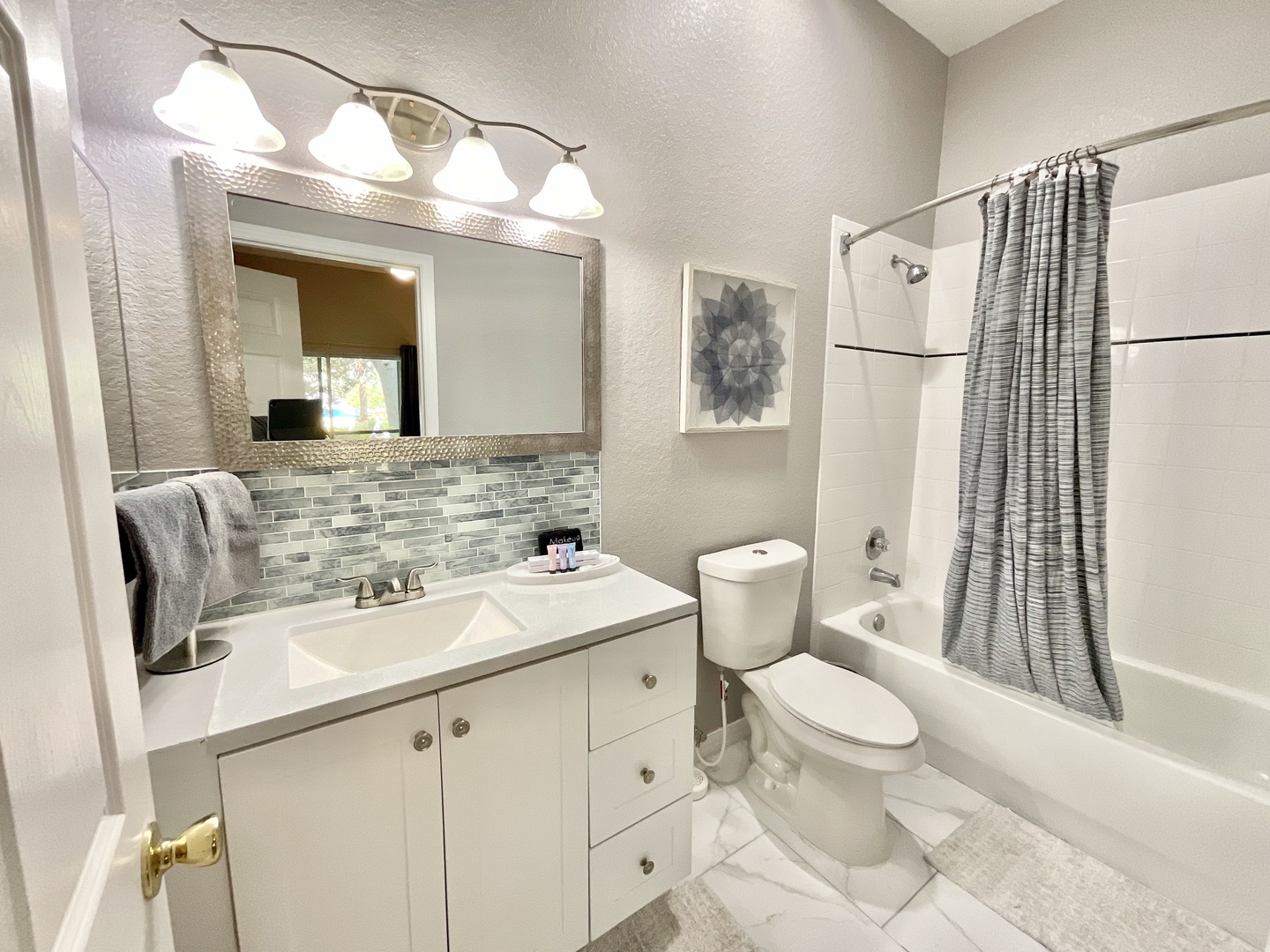 The private king en suite offers a single vanity & shower/tub combo with sleek counter tops and back splash