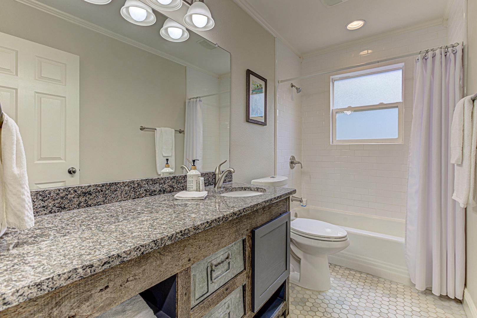 This hall bathroom includes a large single vanity & shower/tub combo