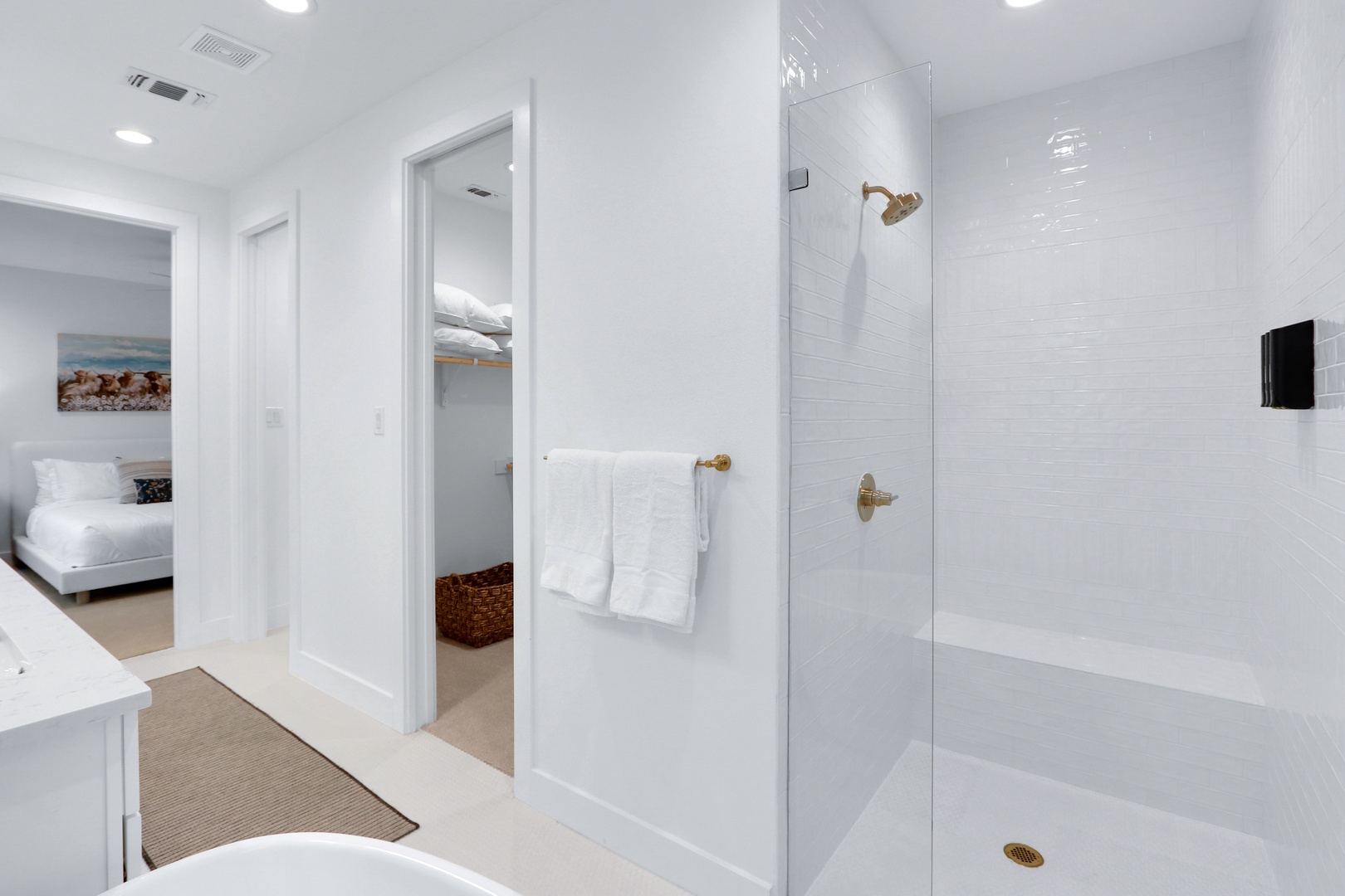 This chic ensuite features dual vanities, glass shower, & luxurious soaking tub