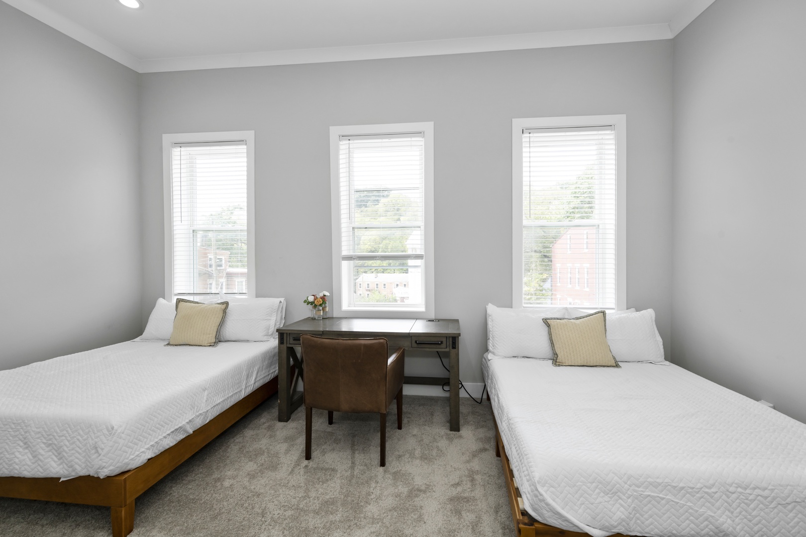 This 2nd floor bedroom offers 2 full beds, a private en suite, & desk workspace