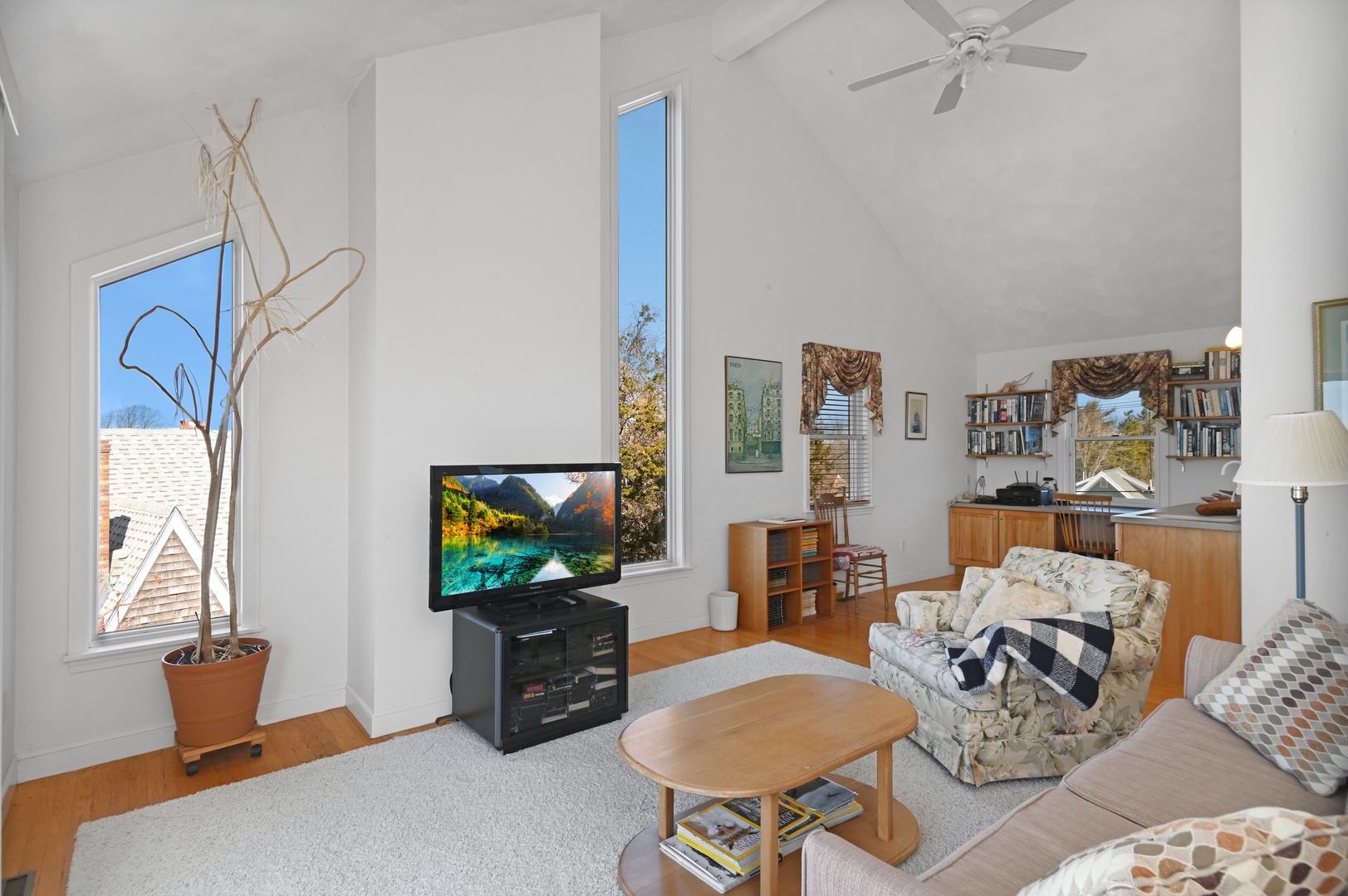 Upstairs living area with cozy seating, TV, work station, and balcony