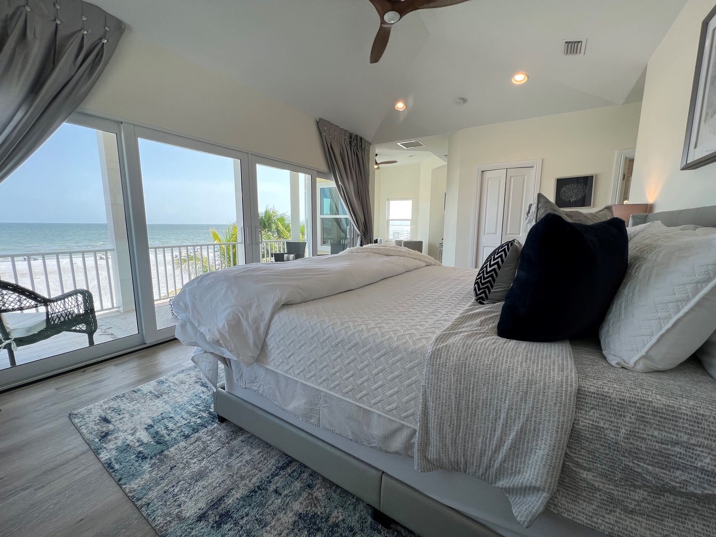 Master bedroom with King bed, sitting area, TV, balcony, and en suite