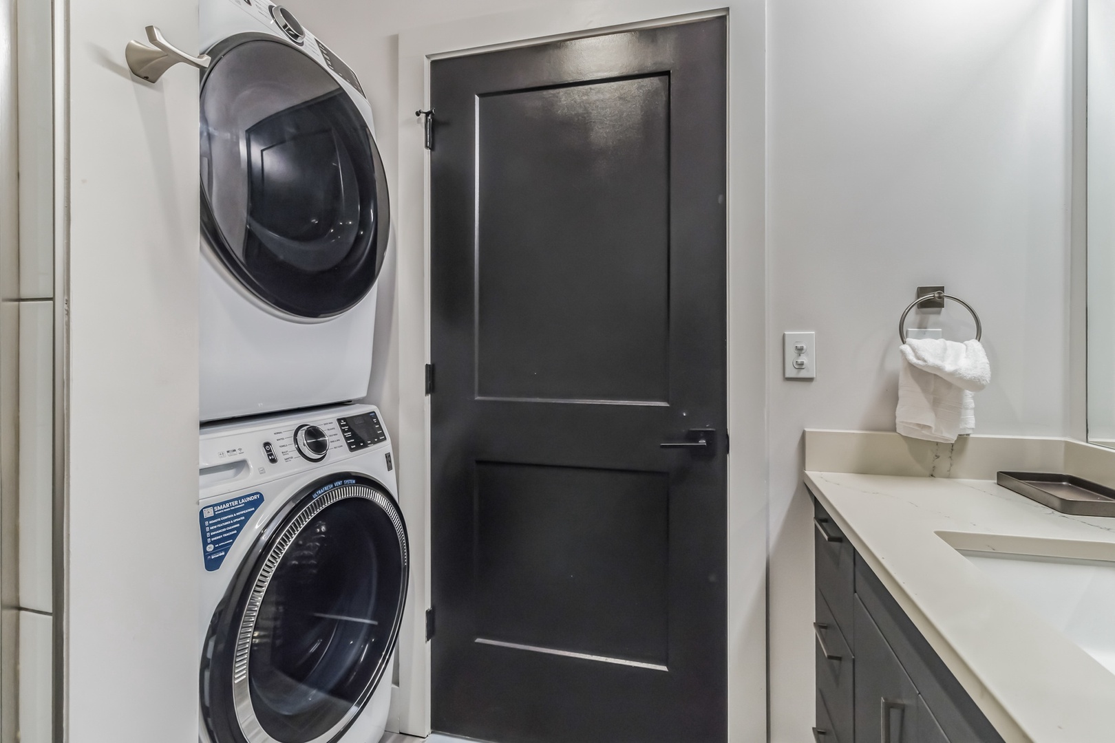 The ensuite features a single vanity, glass shower, & laundry