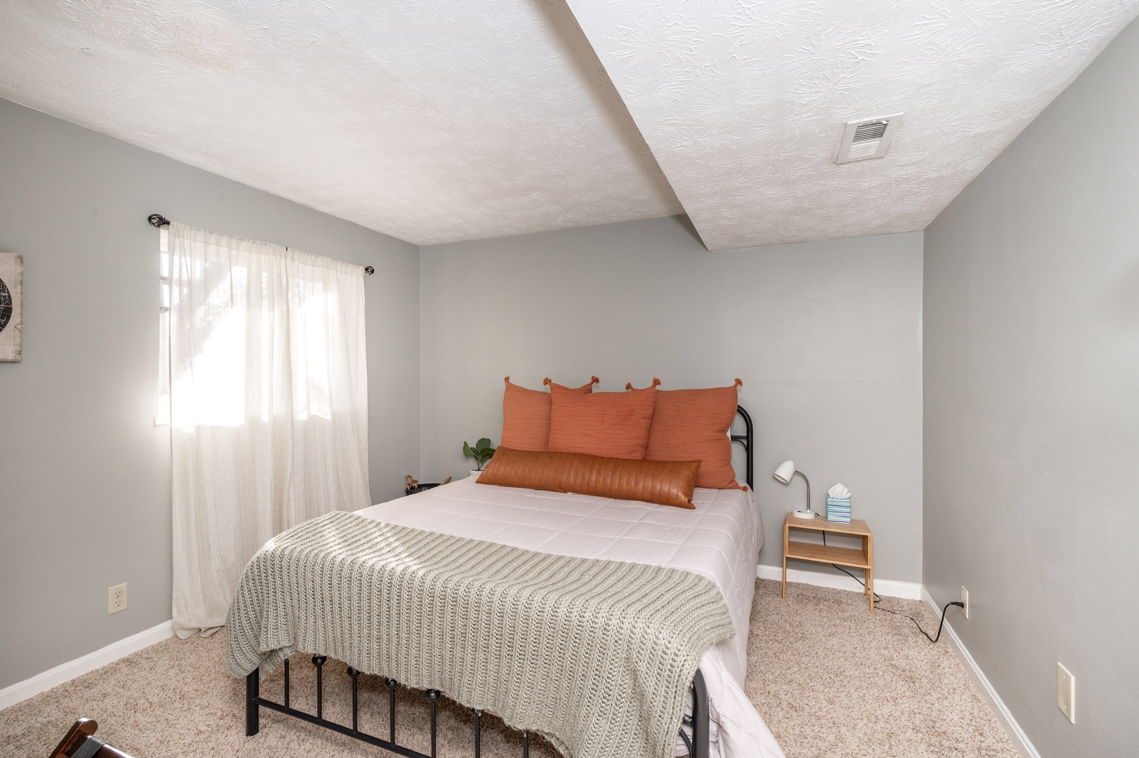 The lower-level bedroom offers privacy & a cozy queen bed