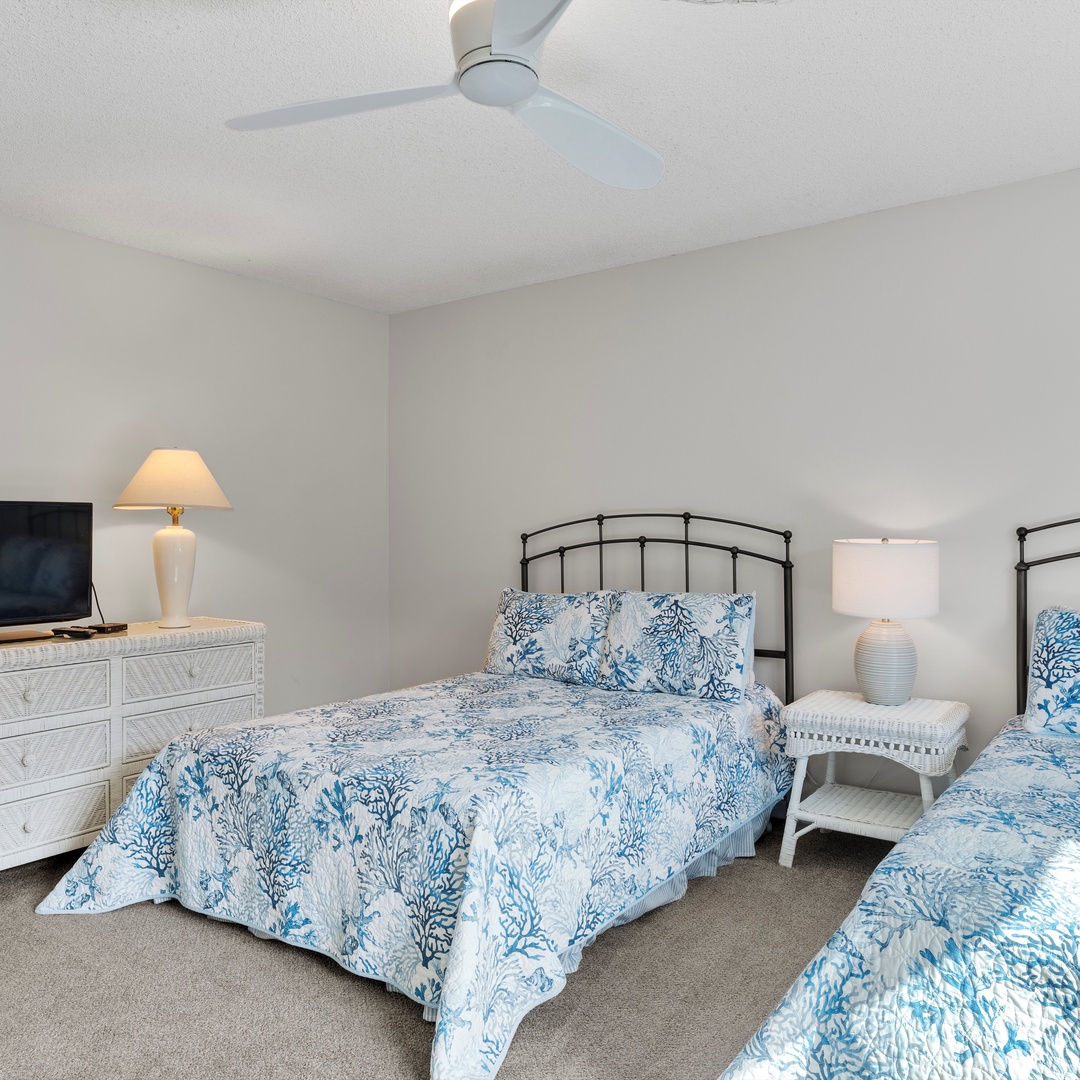 The second bedroom features a pair of plush queen beds & Smart TV