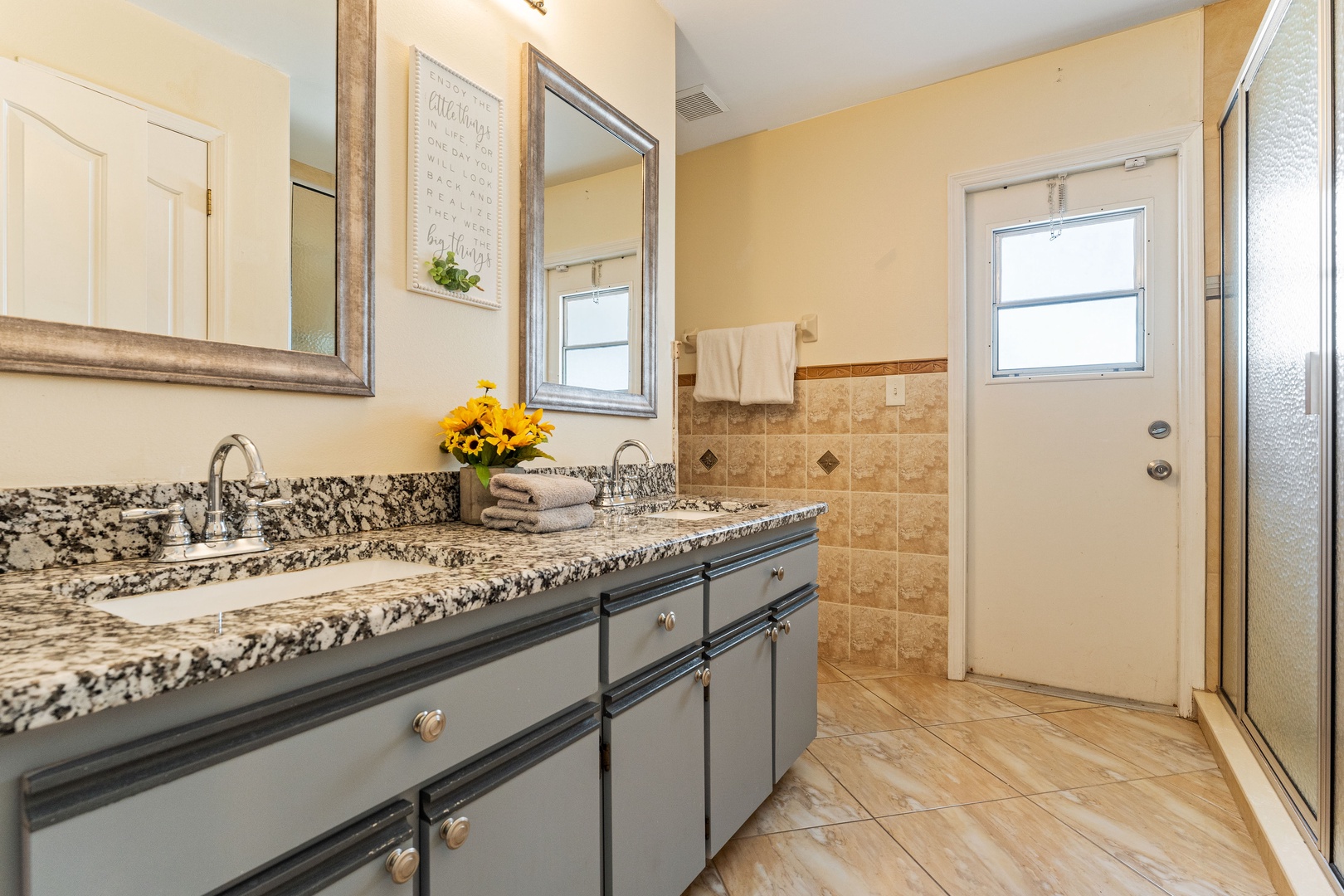 Prepare for the day in the hall bath, featuring a double vanity & shower