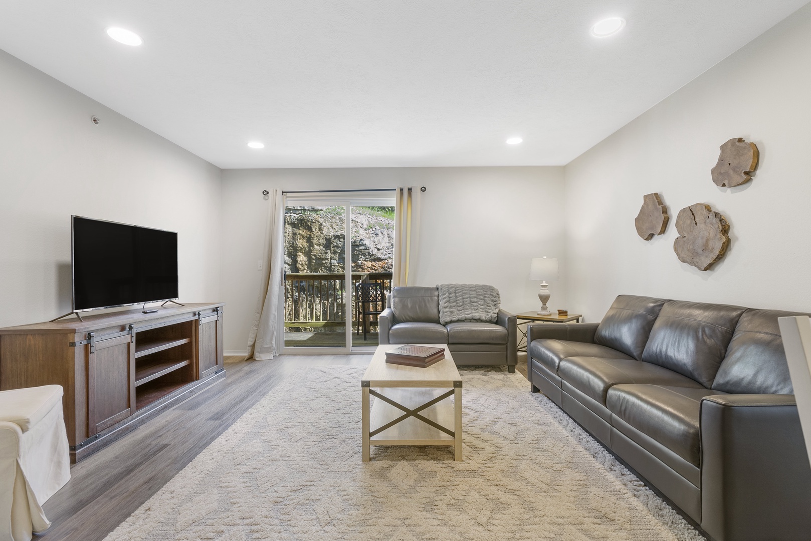 Open living space with ample seating, Smart TV, and balcony access
