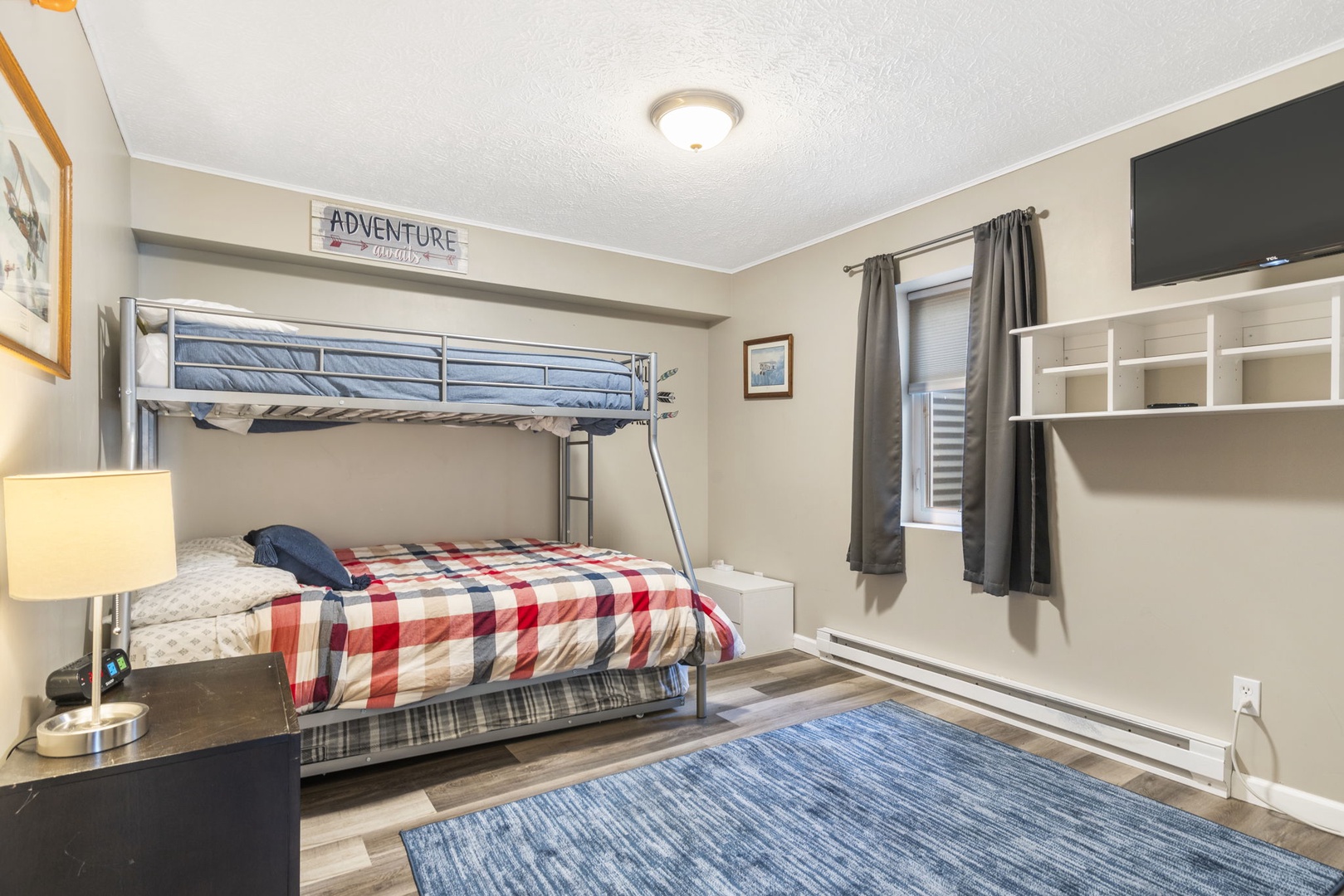 This lower-level bedroom includes a twin-over-full bunkbed, twin trundle, & Smart TV