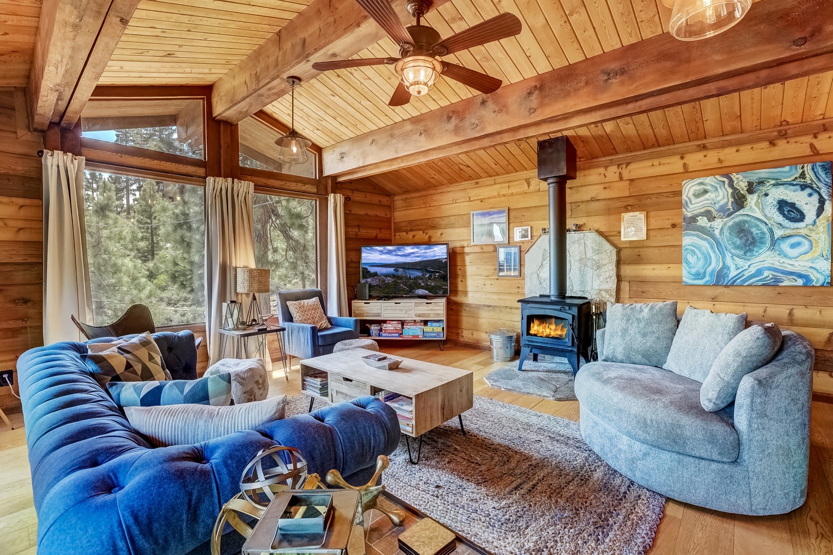Living room with 55” Smart TV, wood burning stove, and balcony access