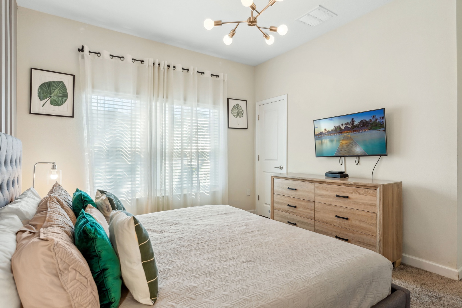 Elegant king bedroom with plush bedding and smart TV