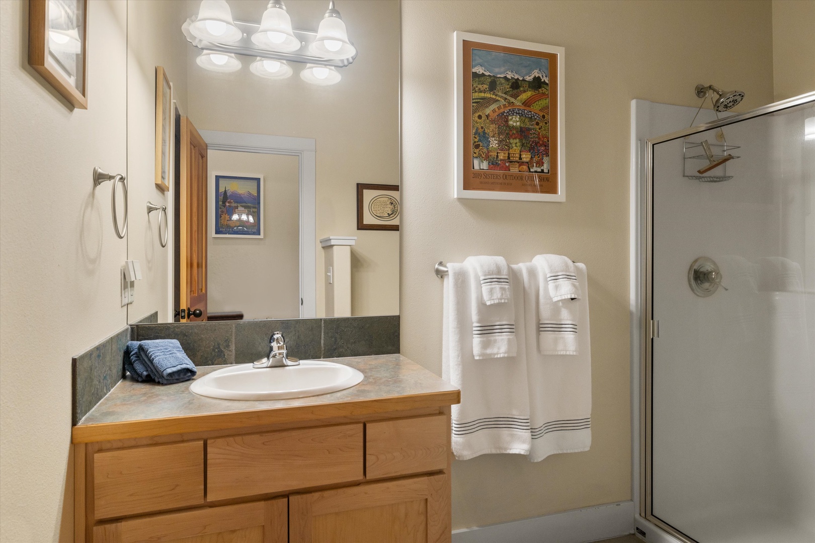 The final full bath features a single vanity, glass shower, and washer/dryer