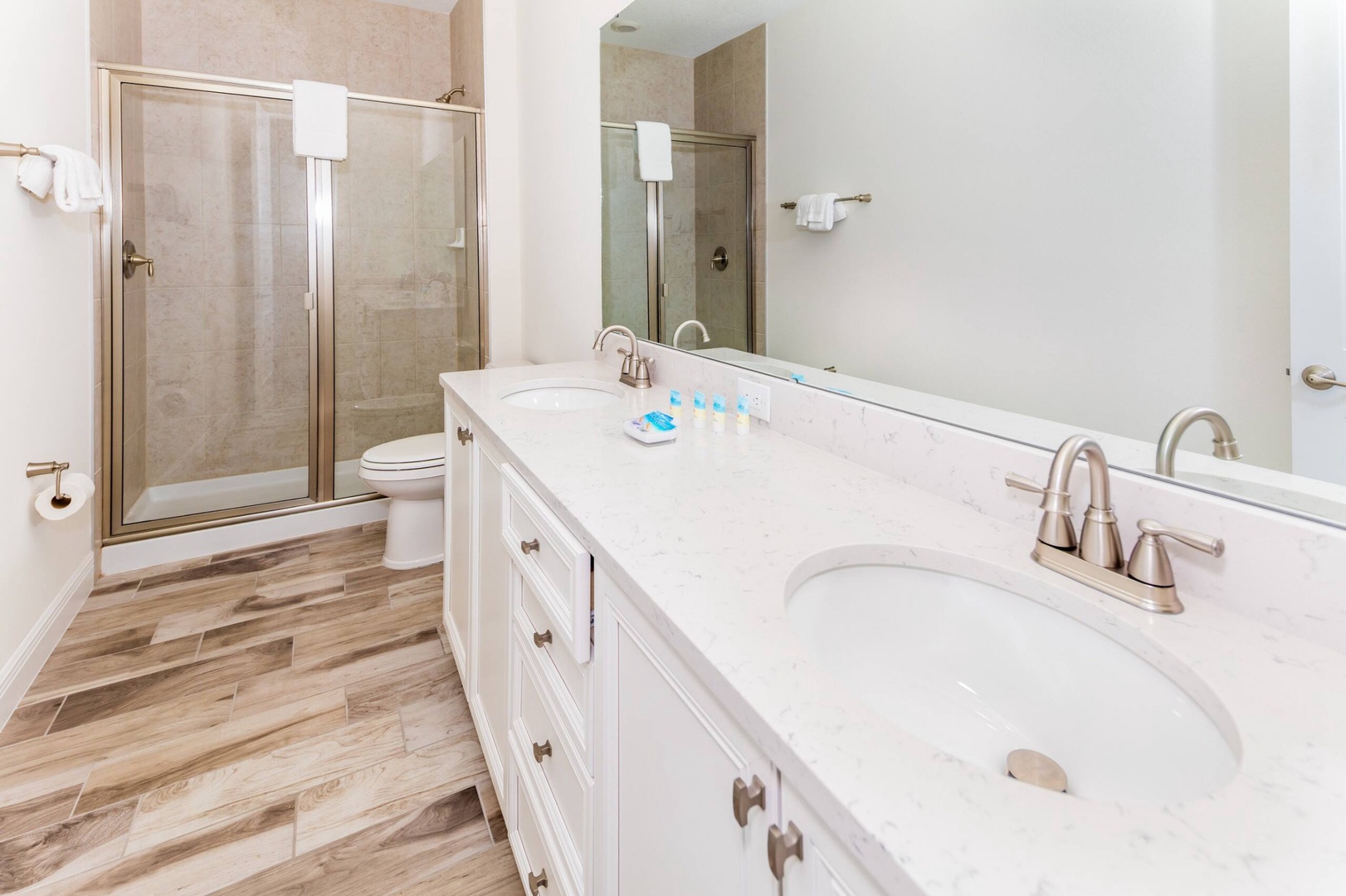 This ensuite bath showcases a double vanity & glass shower