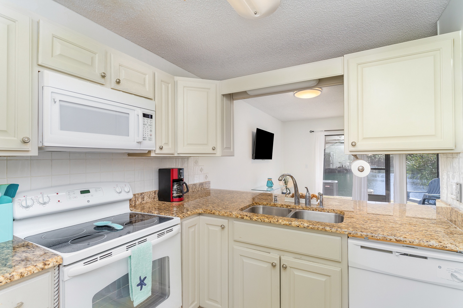 The open, airy kitchen offers ample storage & all the comforts of home