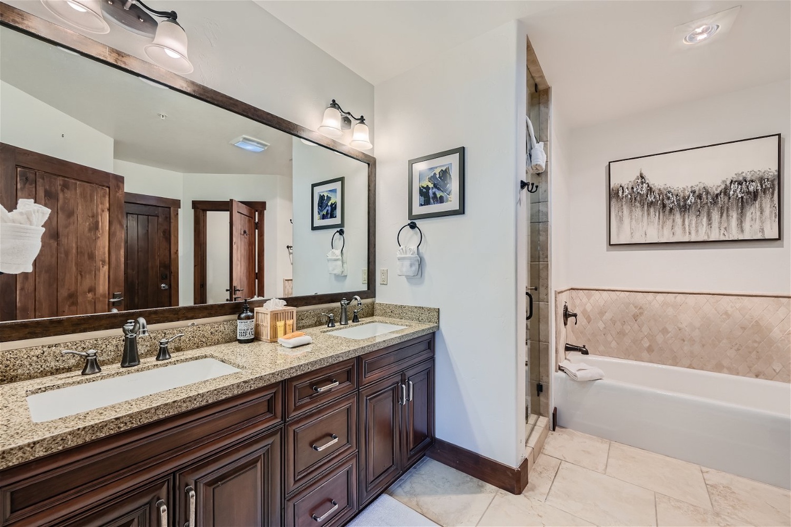 This ensuite features a double vanity, glass shower, & tub