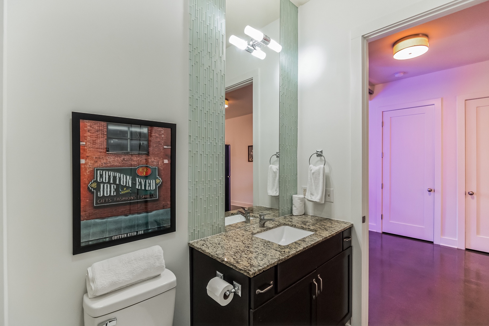 The sleek full bath includes a single vanity & shower/tub combo