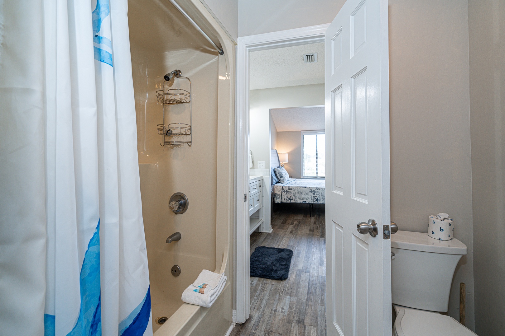 This beachy Jack & Jill bath features dual vanities & a shower/tub combo