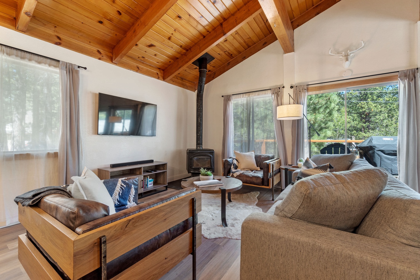 Living space with TV, wood burning stove, Smart TV, and deck access
