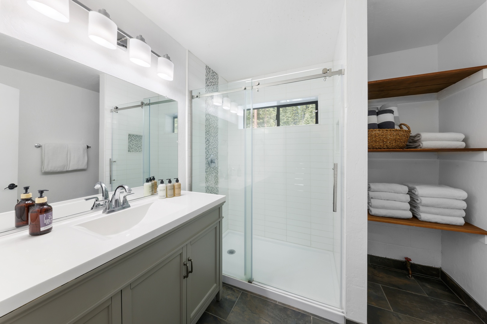 There's No Shortage Of Fun In This Tropical Modern Delray Oasis bathroom  with green tile shower, black iron frames and white sink on wood vanity -  Luxe Interiors + Design