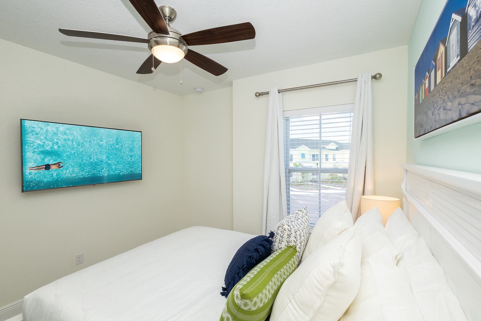 This serene queen bedroom on the 2nd floor includes a Smart TV & ceiling fan