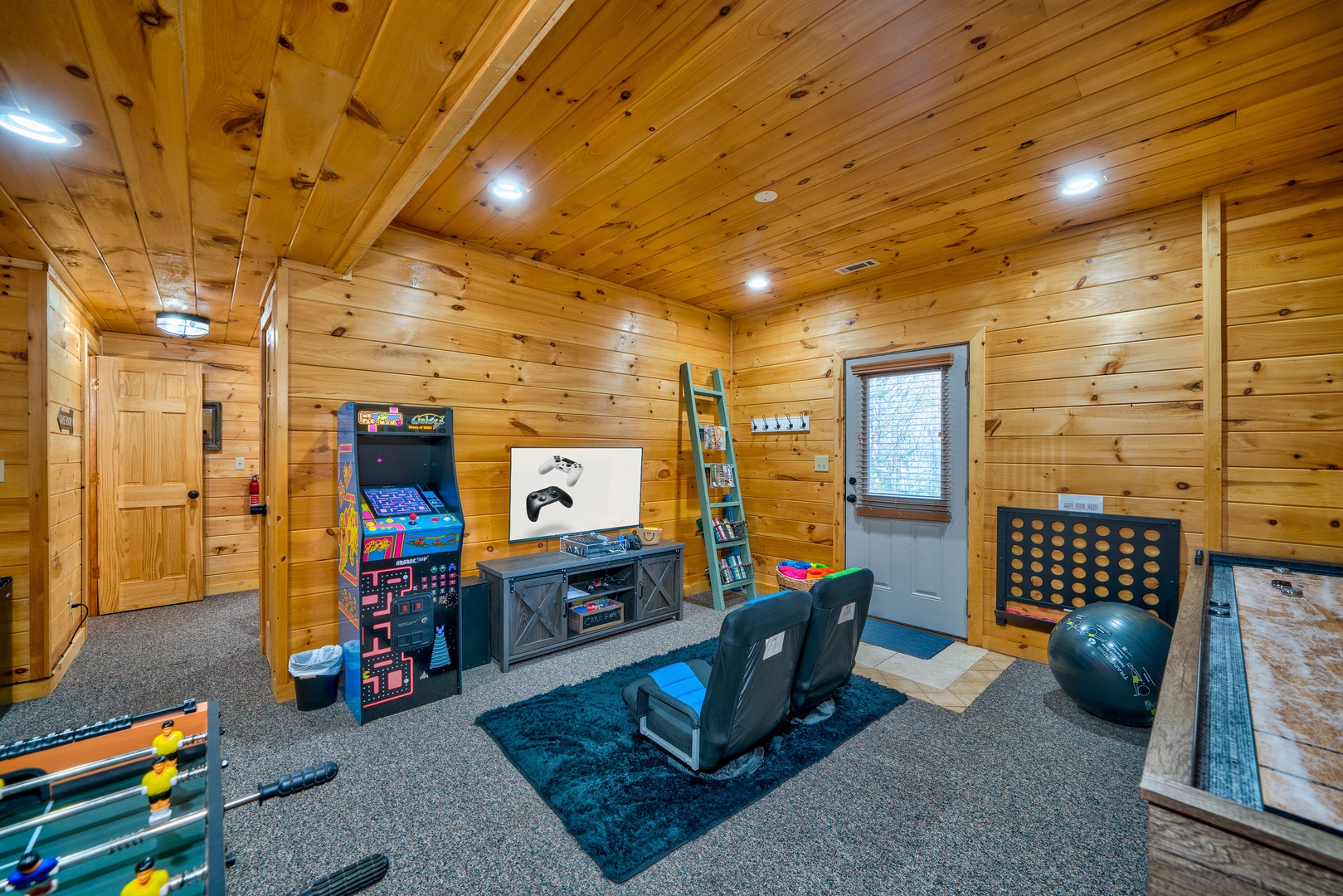 Entertainment haven, with foosball, shuffleboard, arcade, and gaming system in the Game Room
