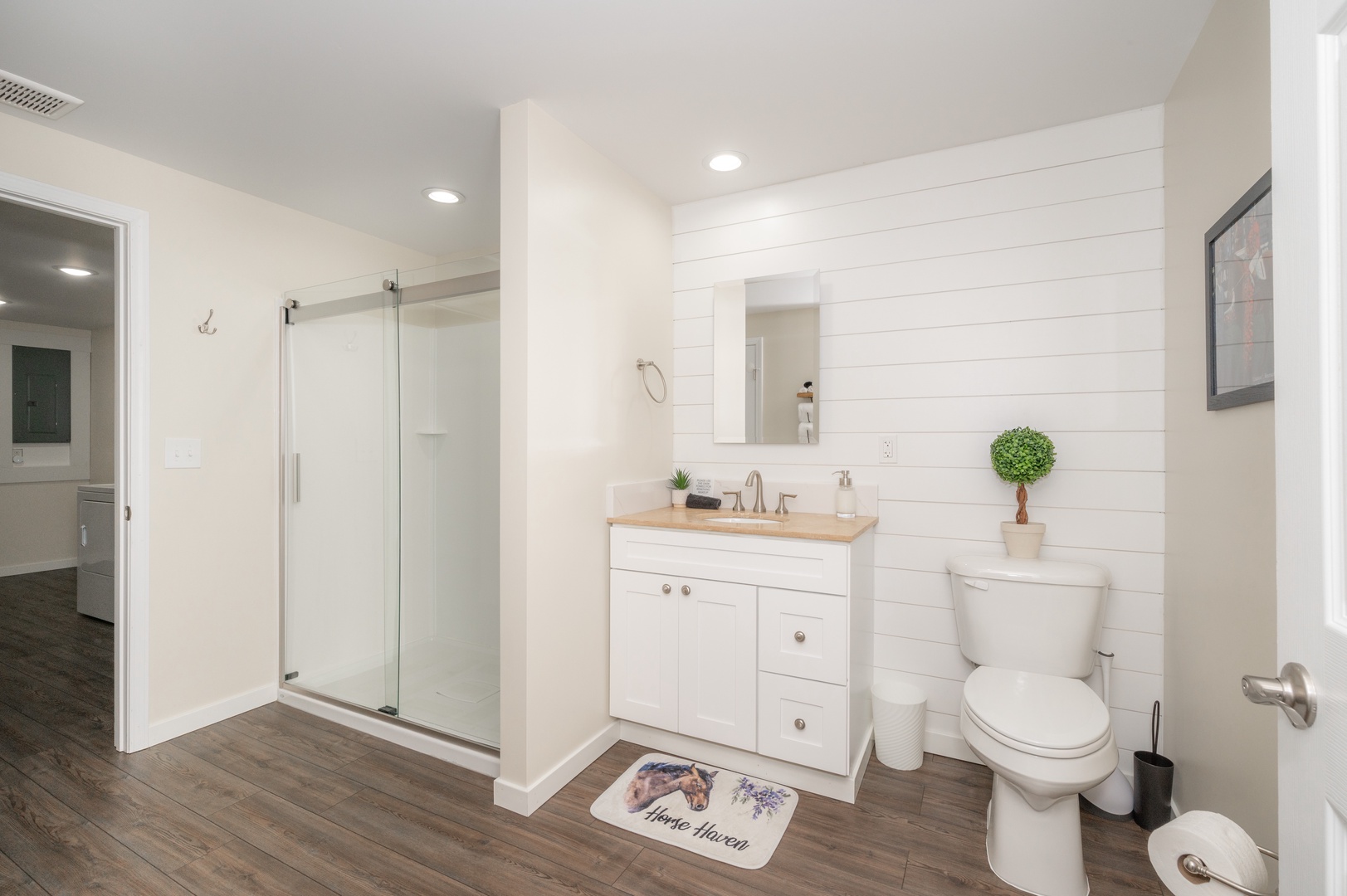 The final full bathroom includes a single vanity & sleek glass shower