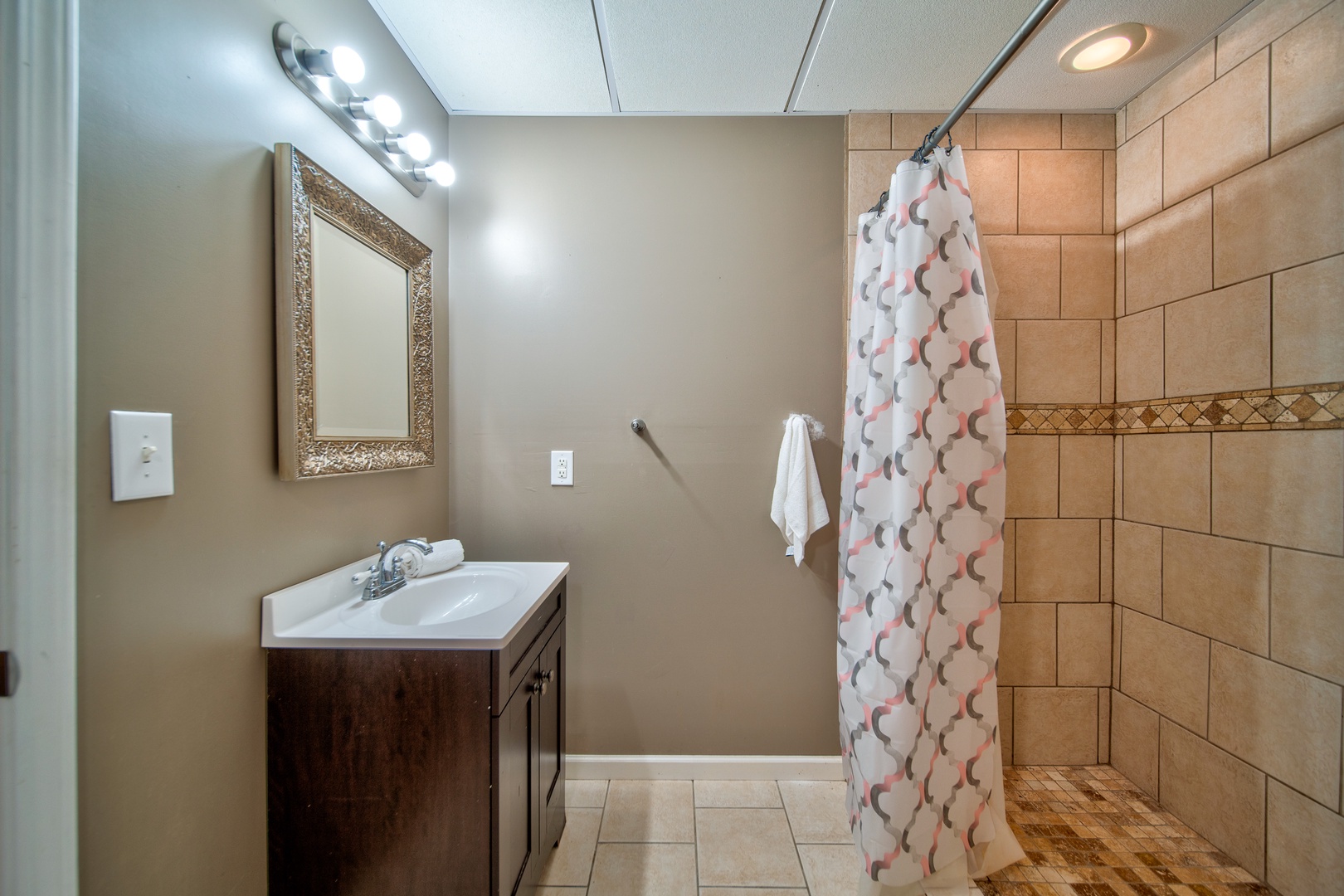 The lower level includes a full bathroom, offering a single vanity & shower