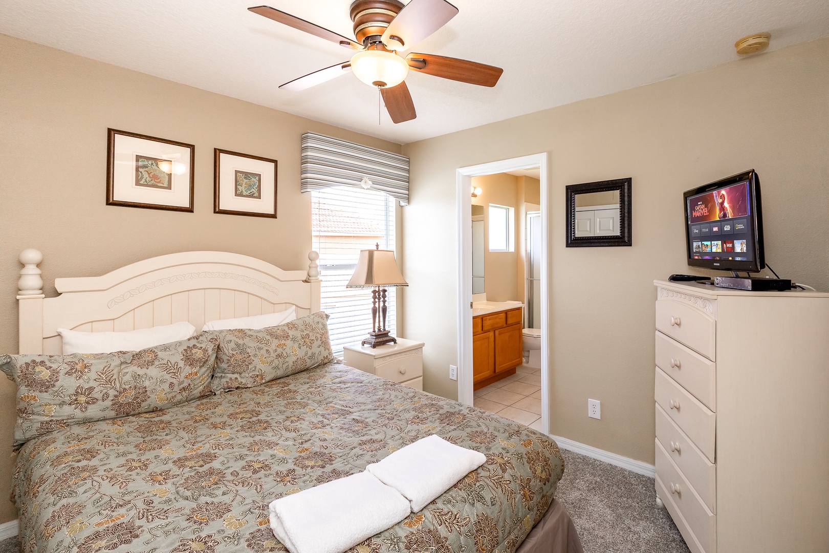 This queen suite offers a private en suite, TV, & ceiling fan