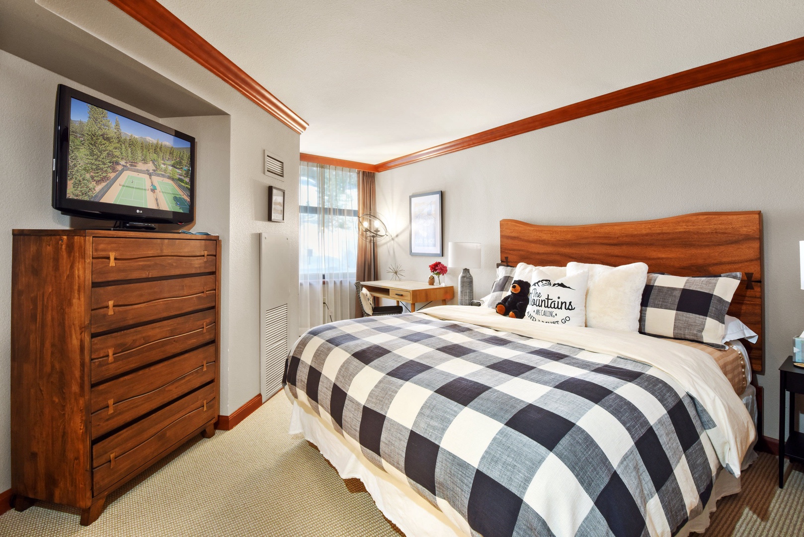 1st bedroom: Queen bed with TV, small workspace, and en suite bathroom