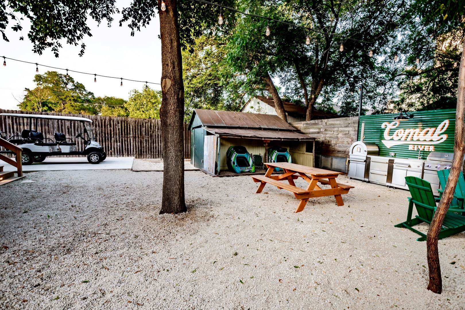 The back yard picnic area boasts a firepit, grill, pizza oven, & outdoor fridge