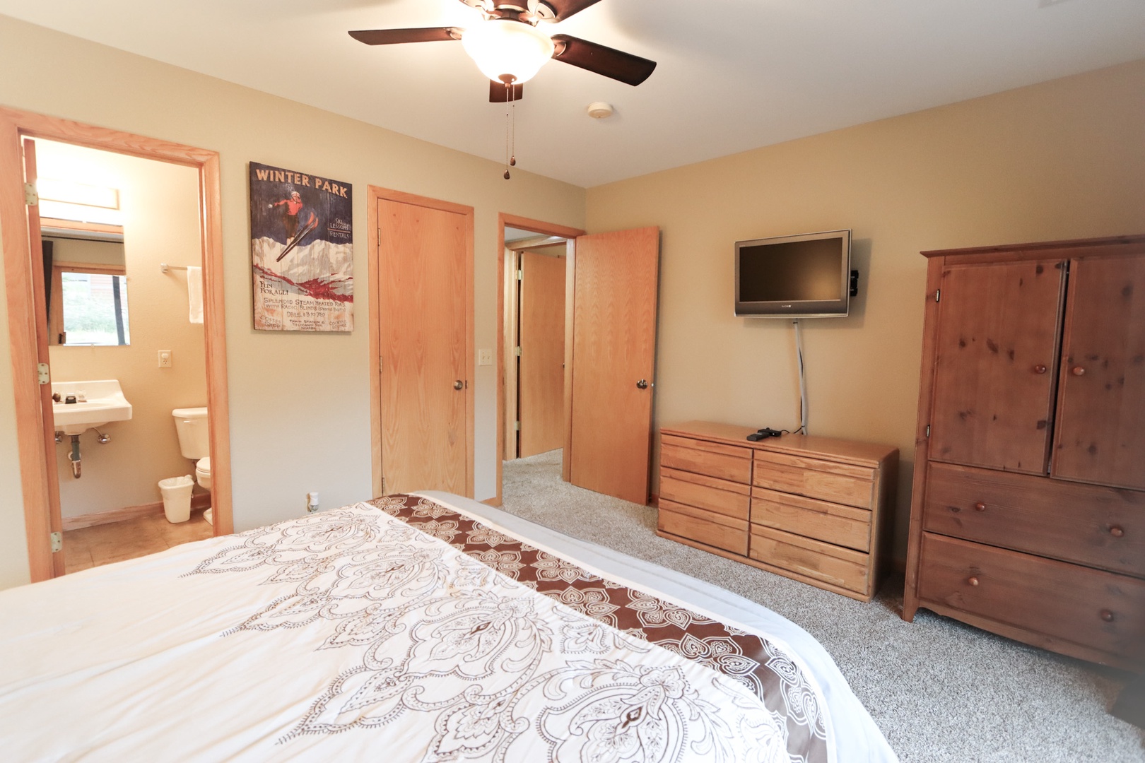 The queen suite offers a private en suite, TV, ceiling fan, & balcony access